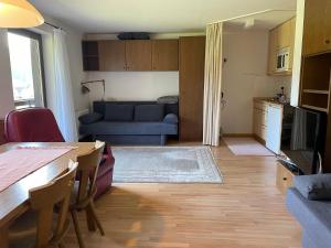 a living room with a blue couch and a table at Fewo 2 am Auweg in Hirschegg +14 photos