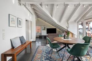 a living room with a table and green chairs at Dachgeschosswohnung in Hofolding in Brunnthal