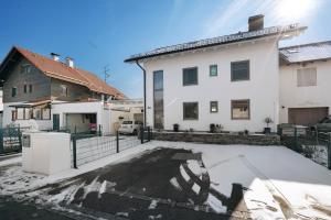 a white house with snow on the driveway at Dachgeschosswohnung in Hofolding in Brunnthal