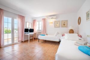 a living room with two beds and a couch and a desk at Villa Es Cantò in Cacla D'or +20 photos