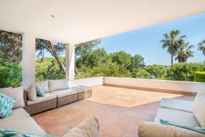 an outdoor living room with a couch and a patio at Villa Es Cantò in Cacla D'or