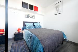a bedroom with a bed with a blue comforter at Appartement Urrugne in Urrugne