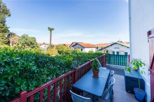 a patio with a blue table and chairs on a balcony at Appartement Urrugne in Urrugne