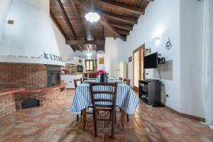 a kitchen with a table with chairs and a fireplace at Villa Rossu in Nuxis