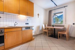 a kitchen with wooden cabinets and a table and a window at Ferienwohnung Hans in Prato allo Stelvio