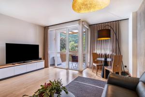 a living room with a television and a table with chairs at Ferienwohnung Hans in Prato allo Stelvio