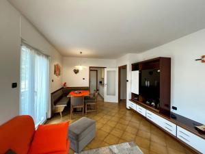 a living room with a couch and a tv and a table at Appartamento Cornon in Tesero