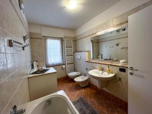 a bathroom with a sink and a toilet and a tub at Appartamento Cornon in Tesero +32 photos