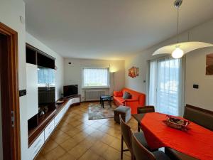 a living room with a red table and a couch at Appartamento Cornon in Tesero