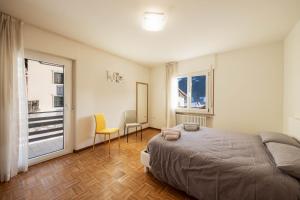 a bedroom with a bed and two chairs and a window at Appartamento Cornon in Tesero