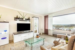 a living room with a flat screen tv and a couch at Ferienwohnung Landblick in Homberg