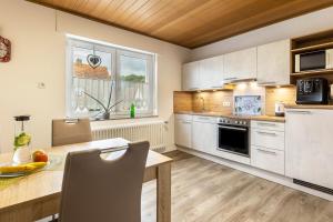 a kitchen with a table and a dining room at Ferienwohnung Landblick in Homberg