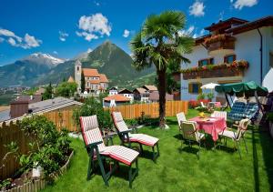a patio with a table and chairs and a mountain at Wieser in Schenna