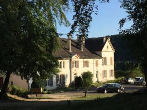 a large white house with a car parked in front at Domaine du Val Bruant in Arc-en-Barrois