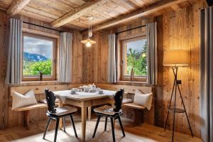a dining room with a table and chairs and windows at Wellness Chalet Samer in Sarntal