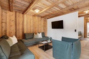 a living room with a couch and a tv at Wellness Chalet Samer in Sarntal