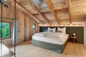 a bedroom with a large bed in a room with wooden walls at Wellness Chalet Samer in Sarntal