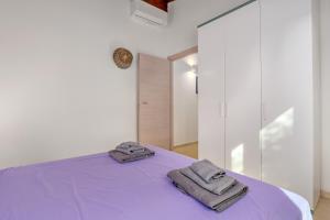 a bedroom with two towels on a purple bed at Stazzu Gallurese in Olbia +28 photos