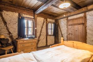 a bedroom with a bed and a dresser and a window at Tannhäuser Mountain Chalet in Predoi