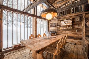 a large wooden table in a room with windows at Tannhäuser Mountain Chalet in Predoi