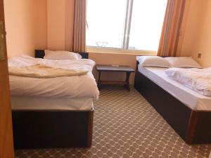 two twin beds in a room with a window at Manakamana hotel in Pāti Bhanjyāng