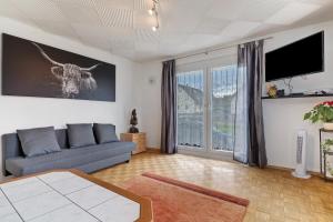 a living room with a couch and a flat screen tv at Ferienwohnung Am Brunnen in Durbach