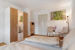 a bedroom with a bed and a table and a chair at Ferienwohnung Am Brunnen in Durbach