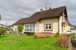 a small yellow house with a brown roof at Ferienwohnung Am Brunnen in Durbach