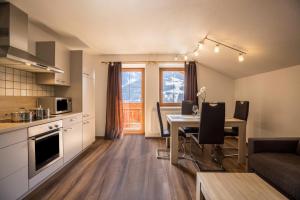 a kitchen and living room with a table and a kitchen and a dining room at Golserhof Sonne in Cadipietra +24 photos