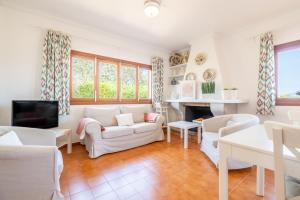 ein Wohnzimmer mit weißen Möbeln und einem Kamin in der Unterkunft Es Viola in Santa Eugènia
