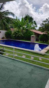 a fence in front of a house with water at Casa da Mari in Caucaia +16 photos