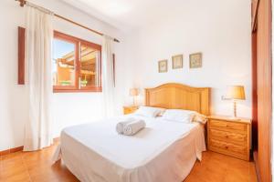 ein Schlafzimmer mit einem großen weißen Bett und einem Fenster in der Unterkunft Es Viola in Santa Eugènia + 21 Fotos