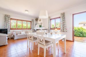 ein Wohnzimmer mit einem weißen Tisch und Stühlen in der Unterkunft Es Viola in Santa Eugènia