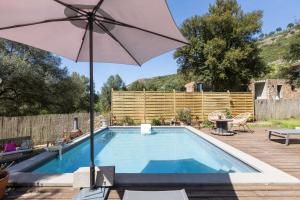 a swimming pool with an umbrella and a table at Santa Maria in Manso +16 photos