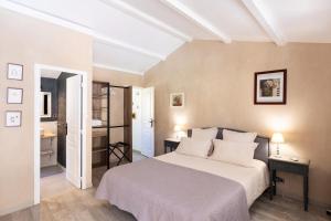 a bedroom with a white bed and a bathroom at Santa Maria in Manso