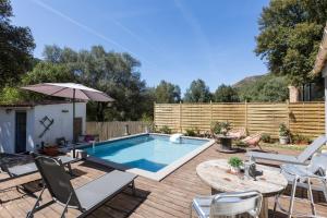a pool with chairs and a table and an umbrella at Santa Maria in Manso