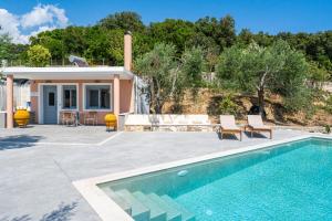 a villa with a swimming pool and a house at Alex bar apartments in Parga