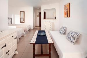 a room with two beds and a couch with a table at Estudio Bloque 90 in Torrox +18 photos