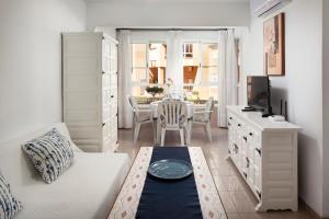 a white living room with a table and a tv at Estudio Bloque 90 in Torrox