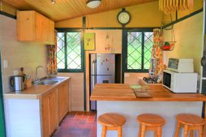 uma cozinha com um balcão, 2 bancos e um frigorífico em Chalet Guata & Exclusividad & Ubicación estratégica em Sesquilé