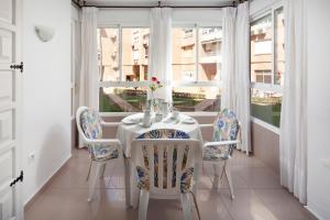 a dining room with a table and chairs and a window at Estudio Bloque 90 in Torrox