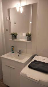 a white bathroom with a sink and a mirror at Au Nid Douillet in Bourges
