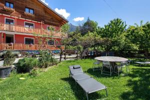 a patio with a table and a bench in the yard at Casa Michod - Nonno Marcel in Châtillon