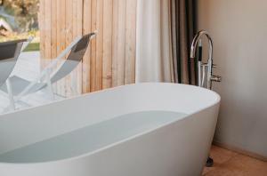 a bath tub with a faucet in a bathroom at Oberplunerhof Luxury Chalet Woods in Chienes +37 photos