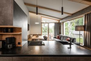 a kitchen and living room with a large window at Oberplunerhof Luxury Chalet Woods in Chienes