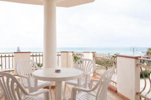 a table and chairs on a balcony with the beach at Appartamento D - Le Terrazze in Ribera