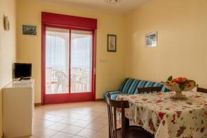 a living room with a table and a red door at Appartamento D - Le Terrazze in Ribera