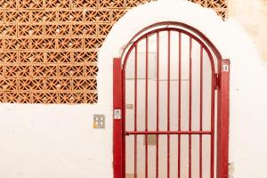 a red door on a white wall with a lattice sqor at Appartamento D - Le Terrazze in Ribera