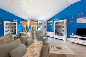 a blue living room with a couch and a tv at Attico con terrazza a Viareggio in Viareggio