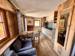 a living room with a table and a kitchen at Chalet du Paradis in Cogne